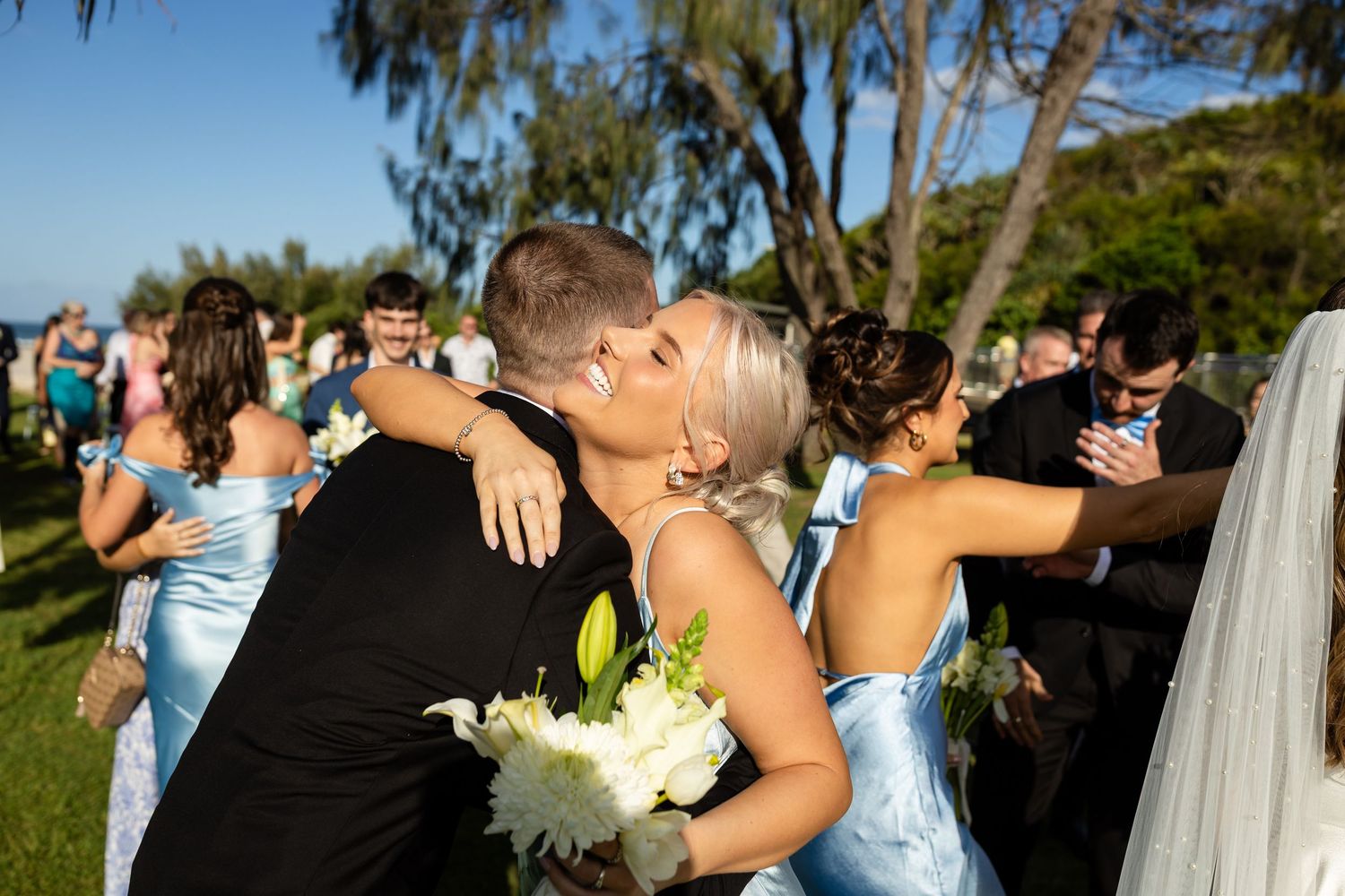 Wedding party poses together on a scenic coastal path with bouquets.beach wedding currumbin surf club wedding