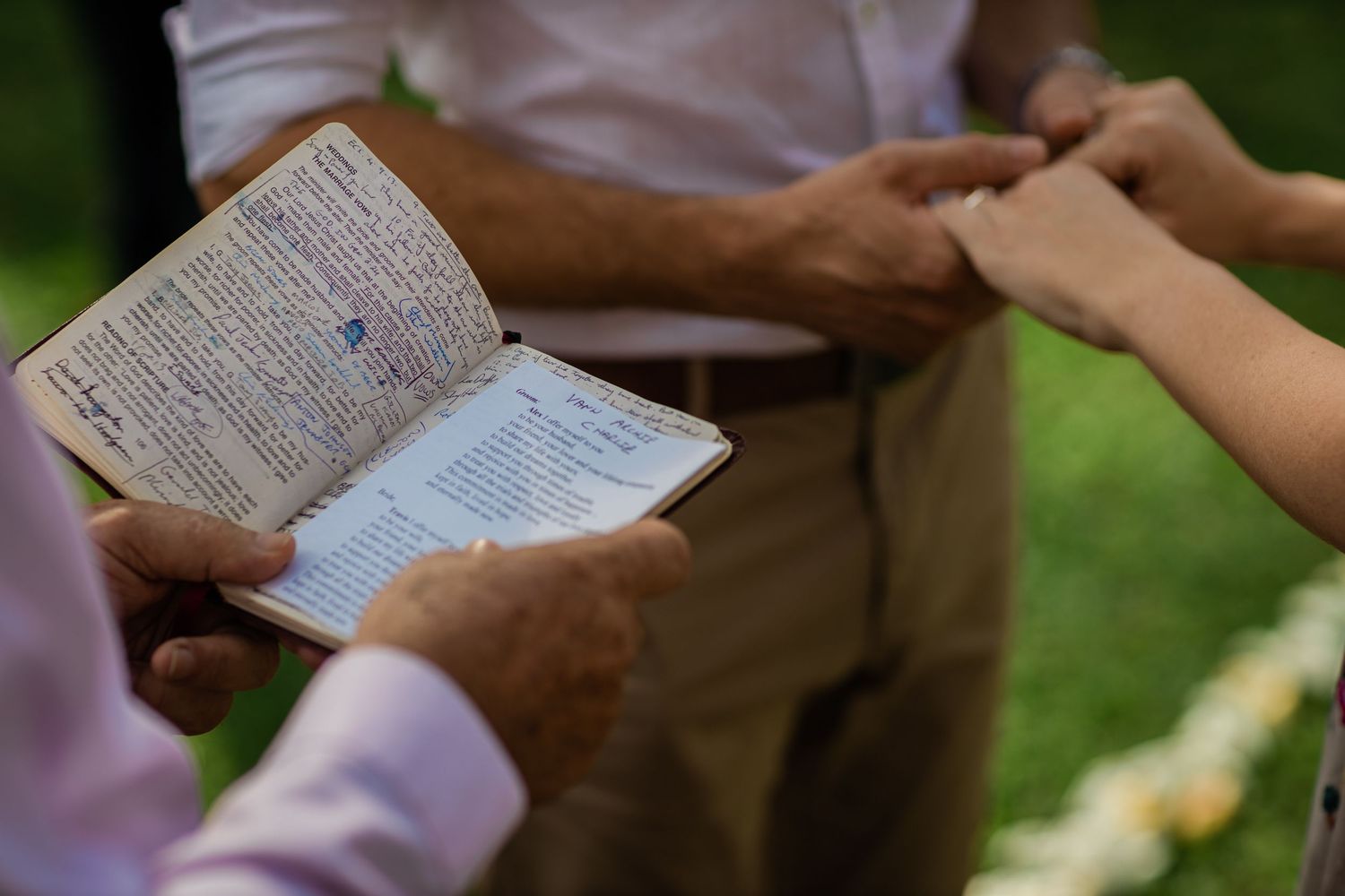 Hands holding paperwork and documents during an outdoor ceremony.