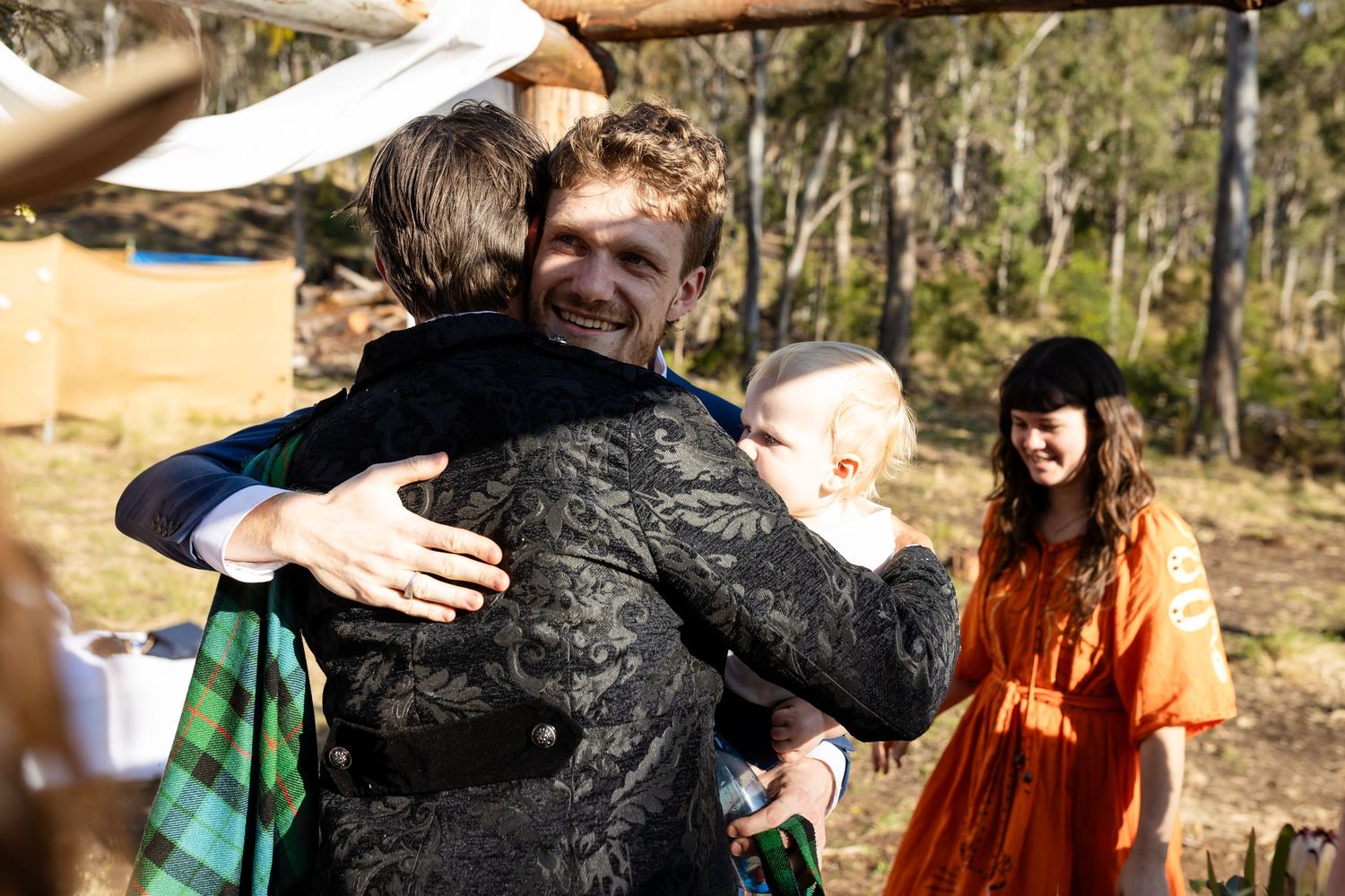 Wedding guests share emotional embraces during outdoor mountain celebration.Gold Coast wedding photographer