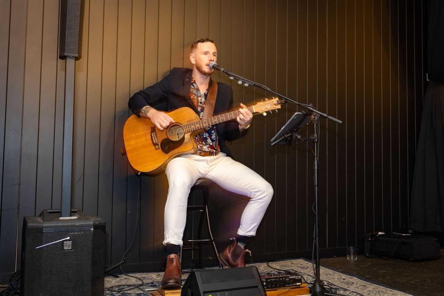 Live band performs on stage at an evening wedding reception with dramatic lighting.