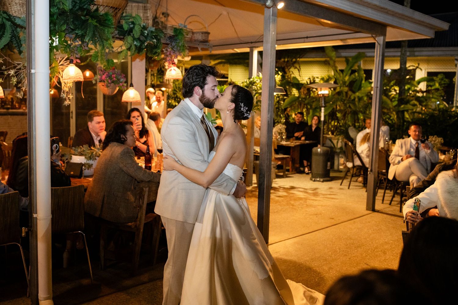 Evening wedding reception under covered patio with warm lighting and dancing guests.Currumbin Valley wedding photography Gold Coast