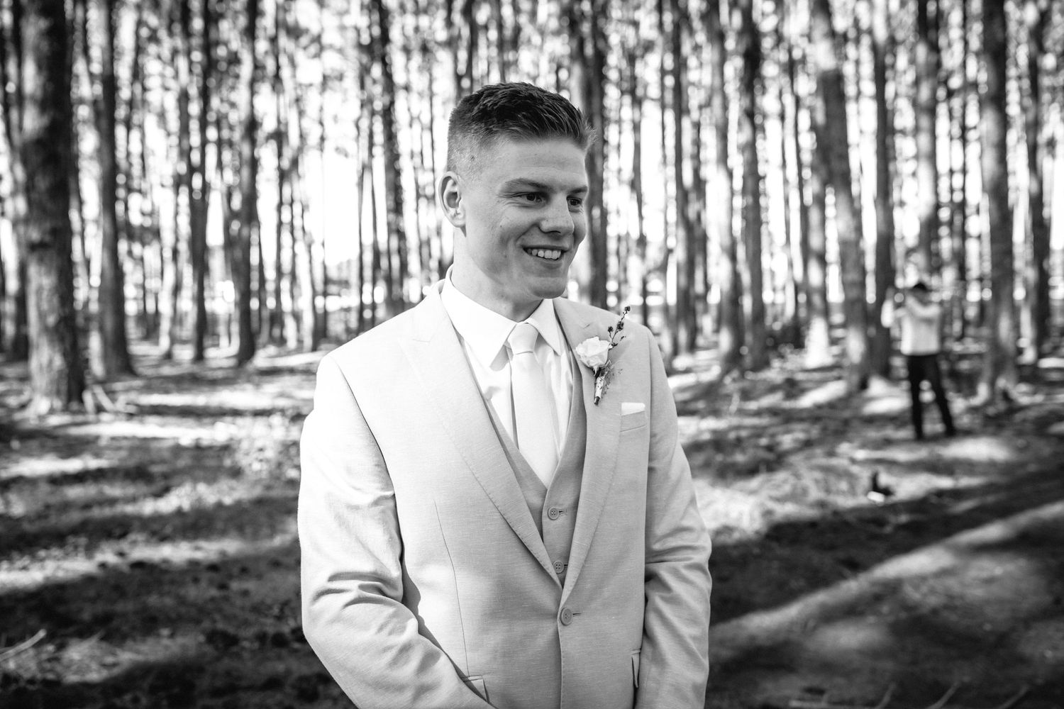 A formal portrait in a pine forest setting with natural light filtering through the trees.