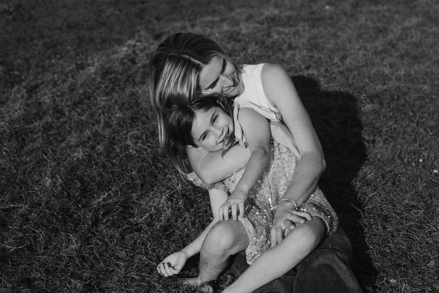 Black and white image of people relaxing together on grass.Gold Coast candid family photographer. Cabarita headland