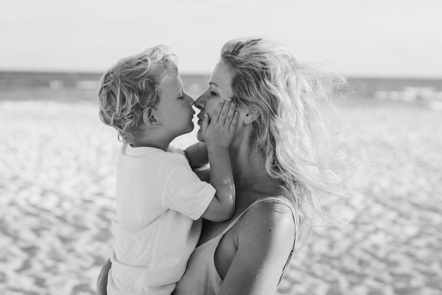 Playful family moment captured in black and white on the beach.Gold Coast candid family photographer.