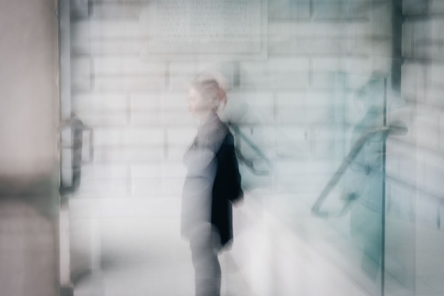 Artistic series of blurred figures against light walls creating ghostly impressions.