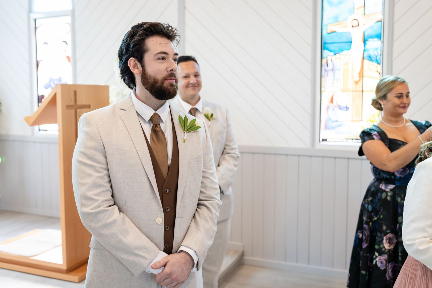 Wedding ceremony moments captured inside a white-paneled chapel with stained glass windows.Gold Coast hinterland wedding photographer