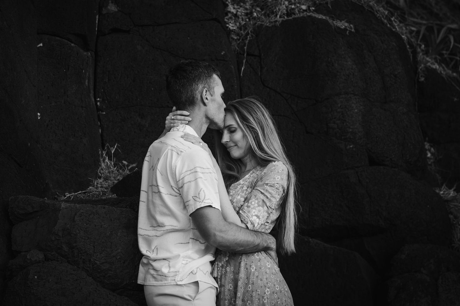 Intimate dance poses captured against dramatic dark stone walls at sunset.Fingal head family photos -  New South Wales