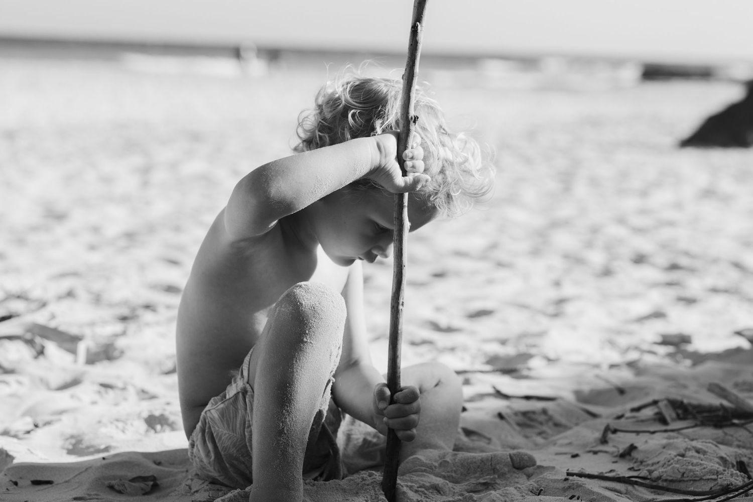 Close-up view of sandy beach footprints with shadows.Family photography Kirra beach Gold Coast.Gold Coast candid family photographer.