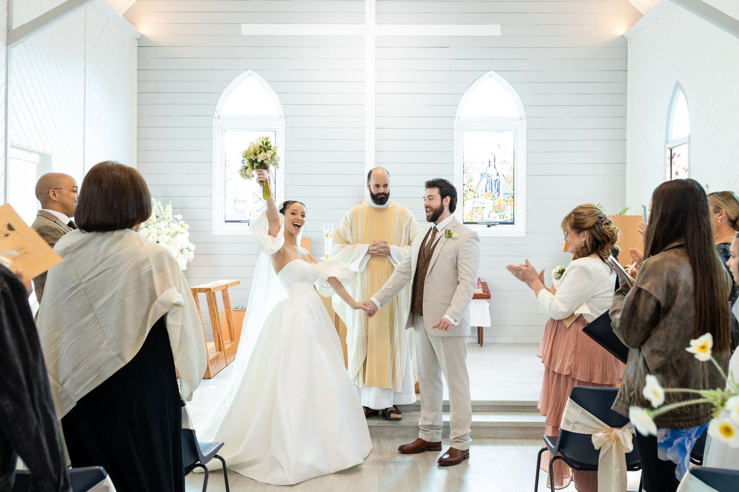 Wide angle view of a modern white chapel wedding ceremony with guests and decorative details.The barrow restaurant mount Nathan wedding