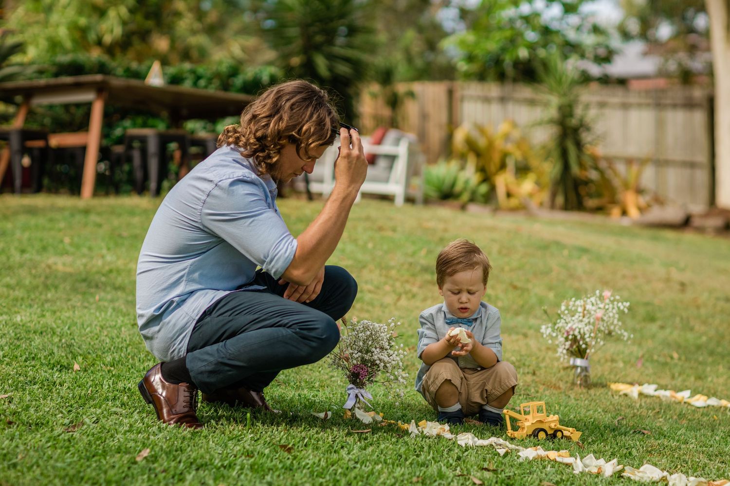 Children playing on grass during an outdoor wedding celebration.