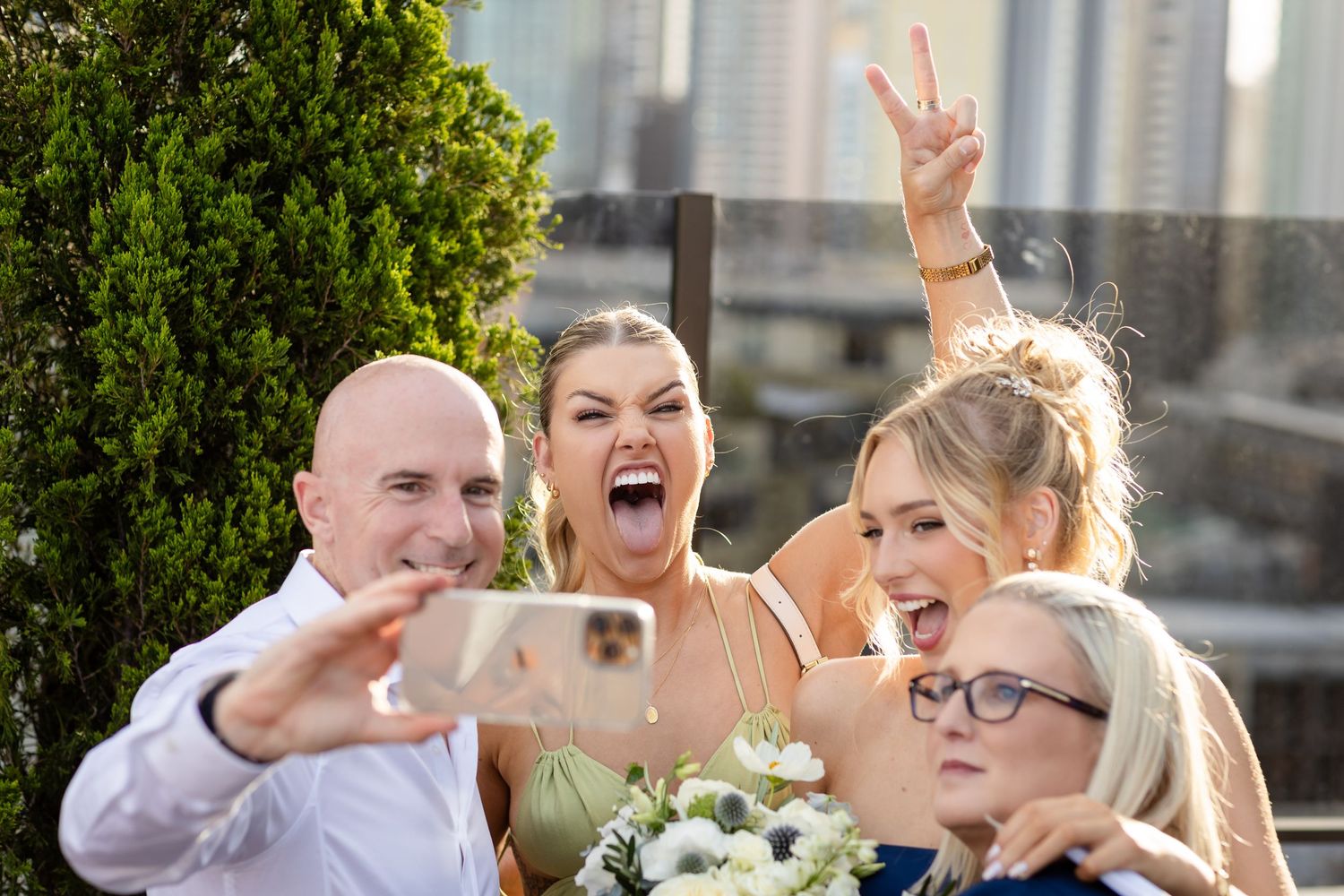 Wedding guests celebrating and posing with fun expressions on a rooftop venue.Brisbane wedding venue