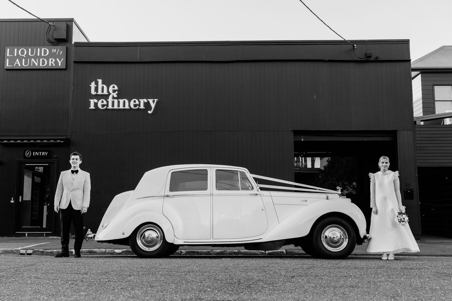Classic vintage white wedding car parked outside The Refinery building.The refinery wedding venue. Brisbane.
