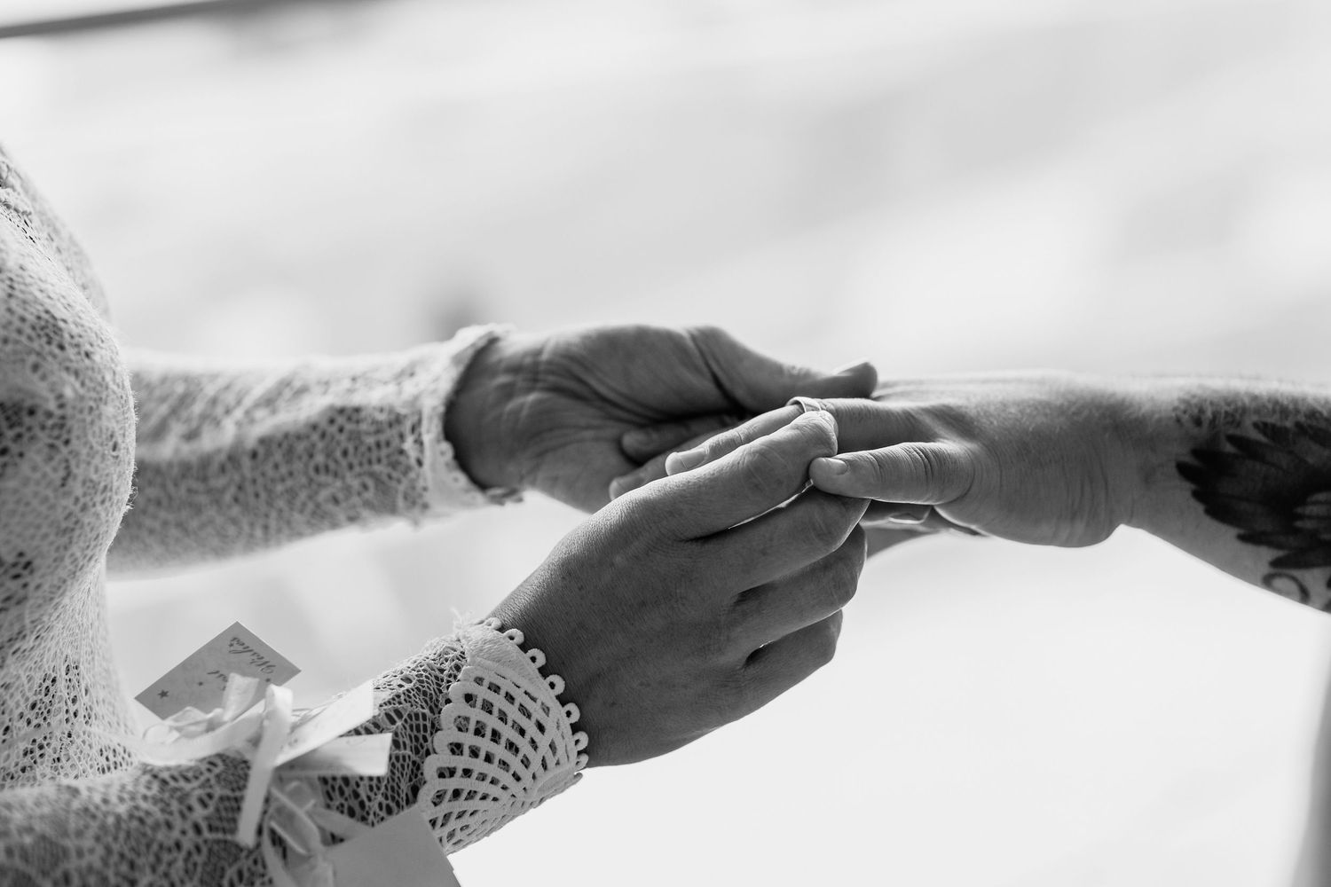 Close-up black and white shot of hands exchanging rings in an intimate wedding ceremony moment.candid wedding photography Gold Coast