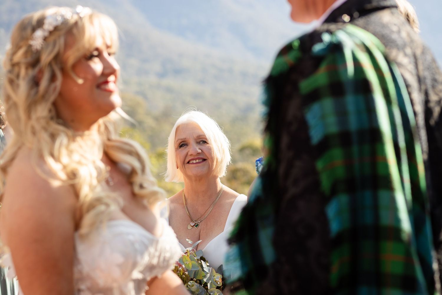 Bridesmaids in pastel dresses and groomsmen gather for outdoor wedding photos.