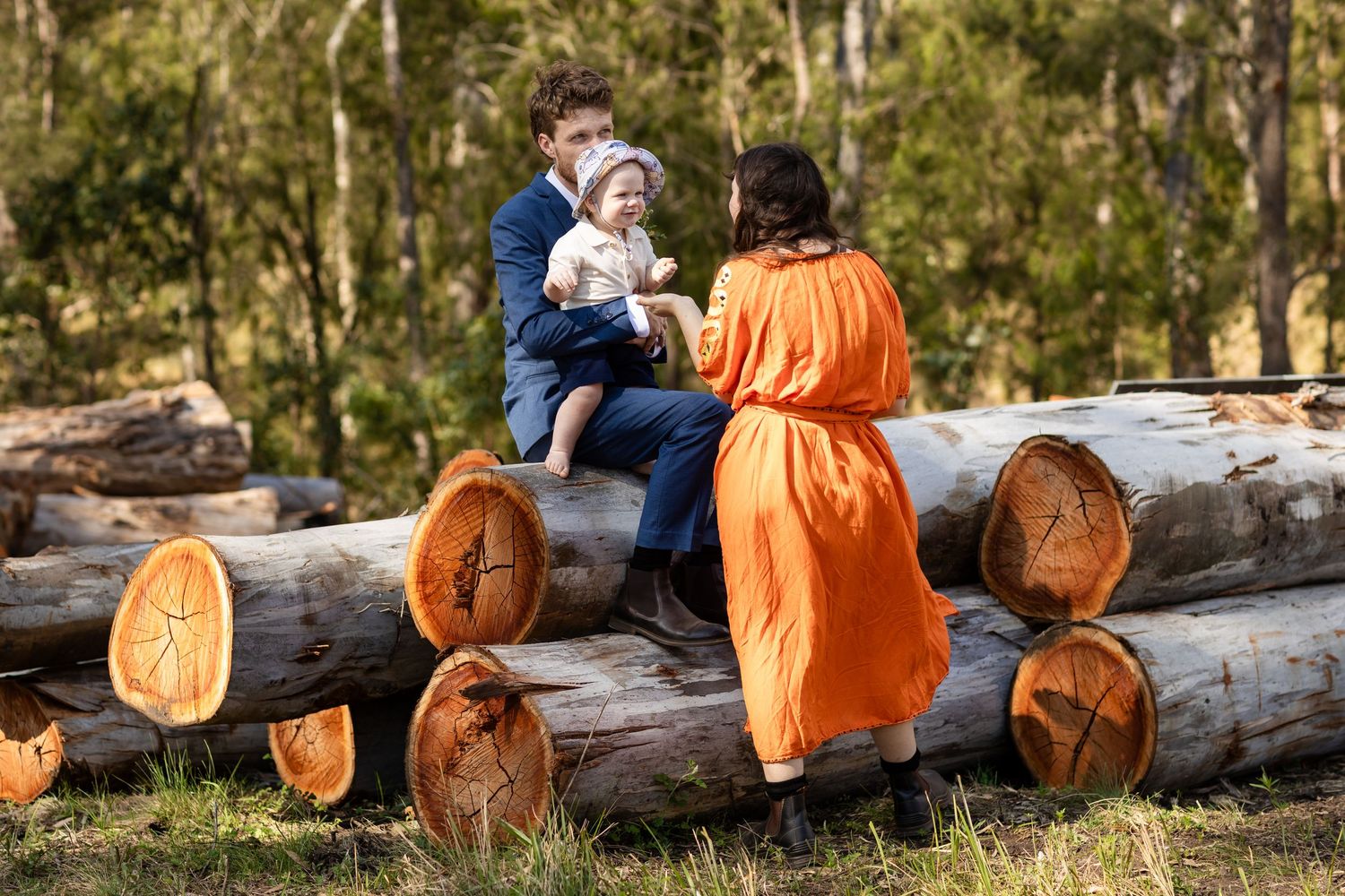People sitting casually on wooden logs arranged as outdoor seating.