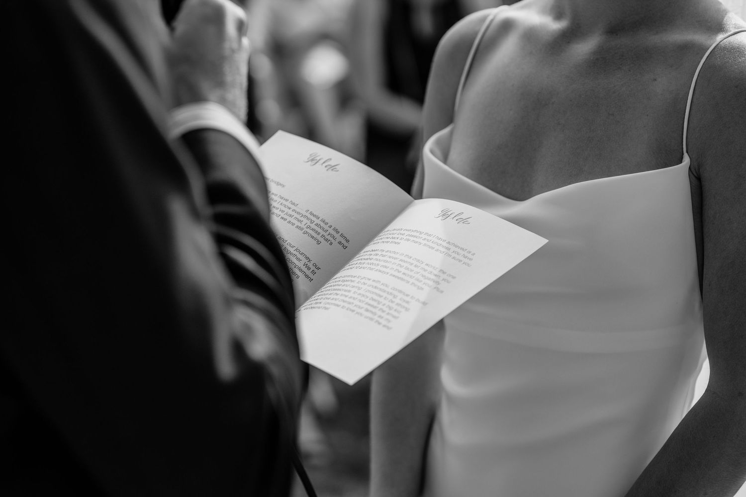Close-up of hands holding wedding ceremony programs during outdoor service.Miami Burleigh heads beach wedding