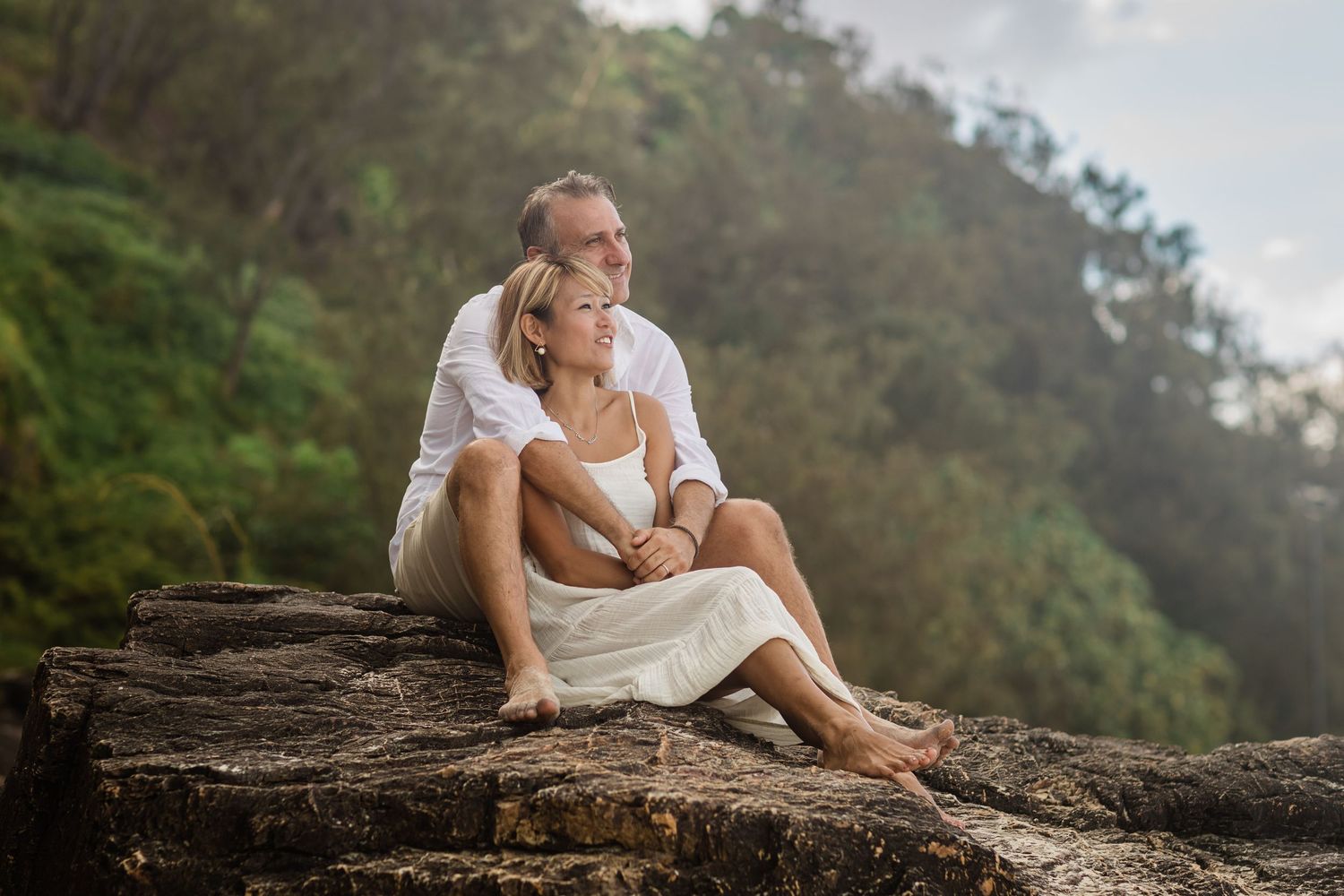 Romantic couple's photoshoot on mossy rocks in lush forest setting.Gold Coast candid family photographer.