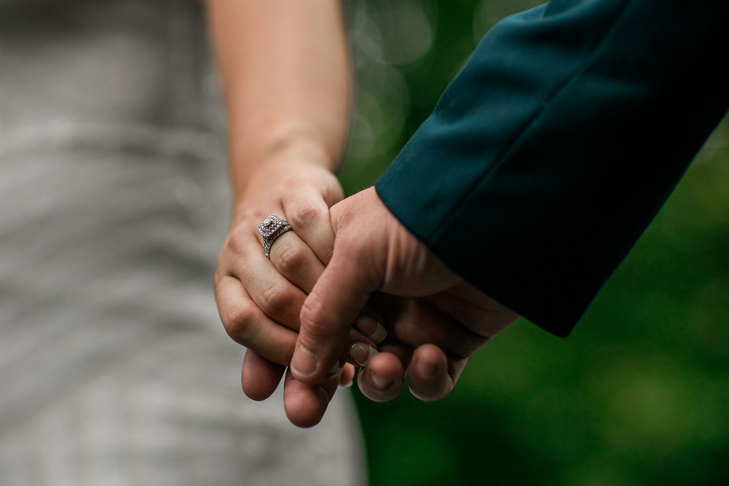 A close-up series of hands exchanging wedding rings during a marriage ceremony against a blurred green background.