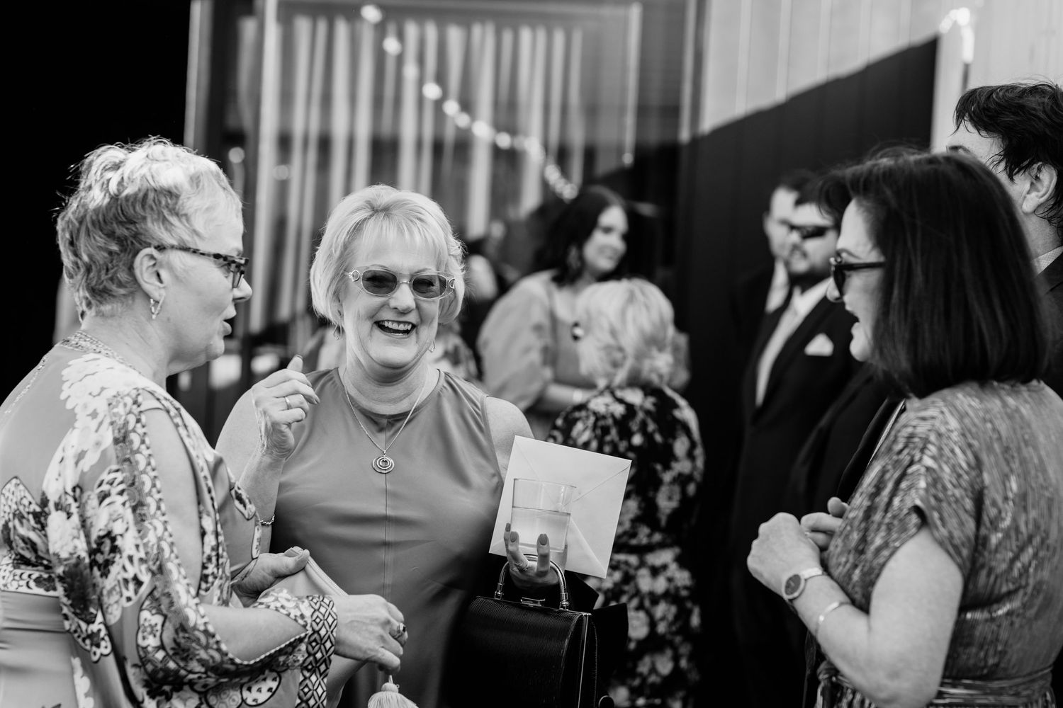 Candid moments of guests socializing at an elegant wedding reception.