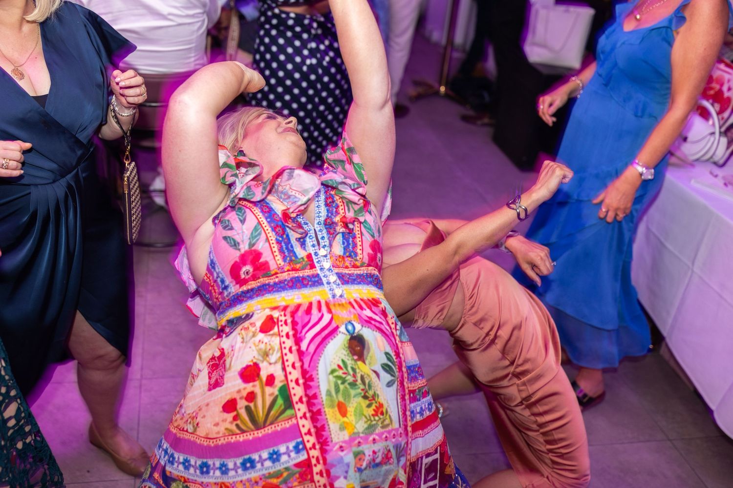 Lively dance floor scene with guests in colorful dresses enjoying the celebration.