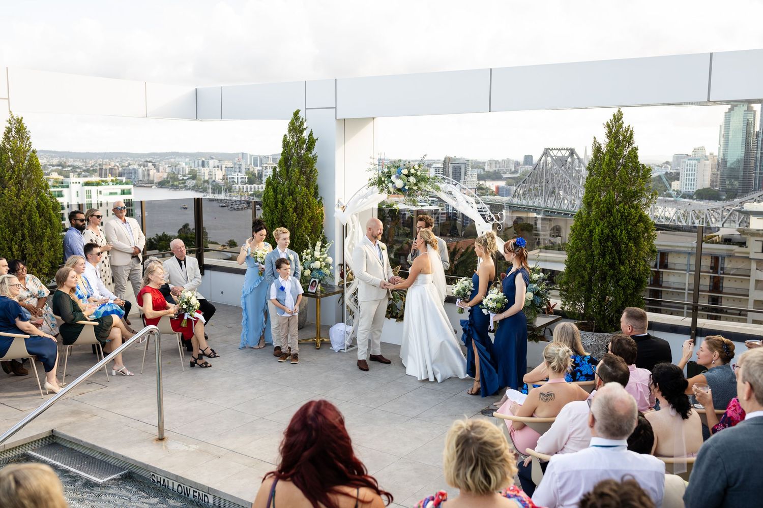 Panoramic view of a rooftop wedding ceremony space with white chairs and decorative elements.