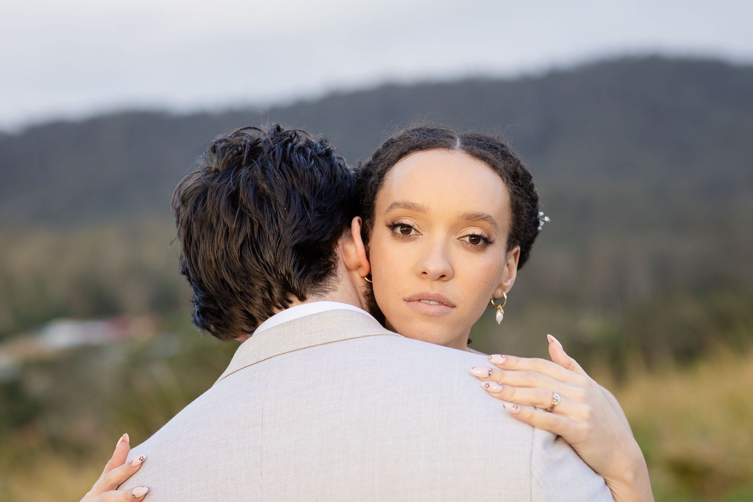 A tender moment between newlyweds against a mountain backdrop on their wedding day.The barrow restaurant mount Nathan wedding