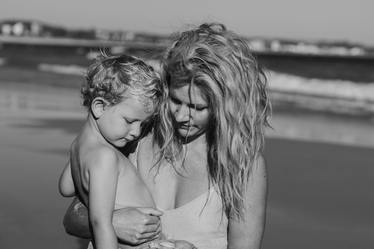 A joyful black and white beach scene with people embracing.Gold Coast candid family photographer.