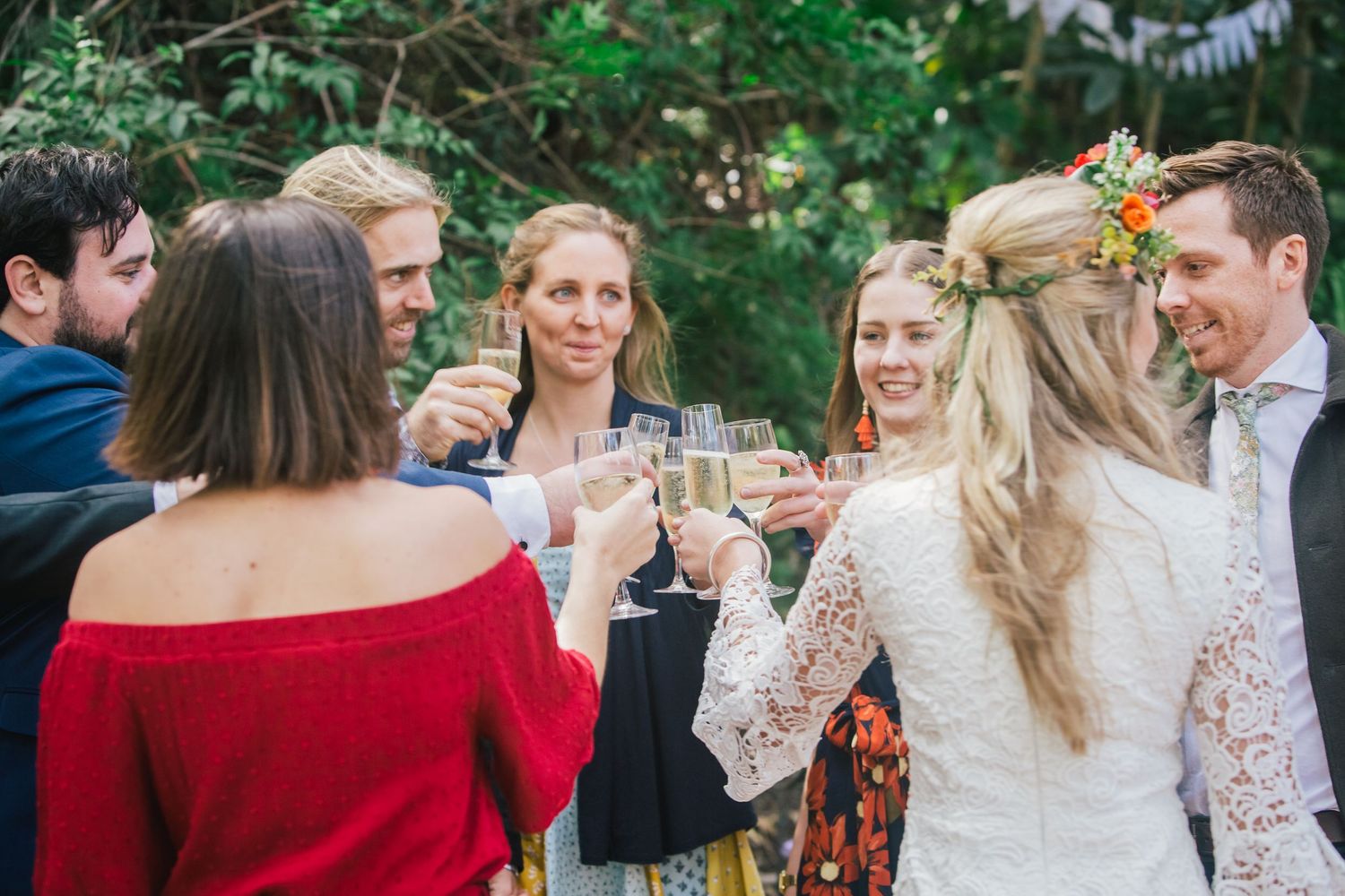 Wedding guests toasting with champagne glasses at outdoor garden reception.DIY wedding Gold Coast elopement photographer Gold Coast
