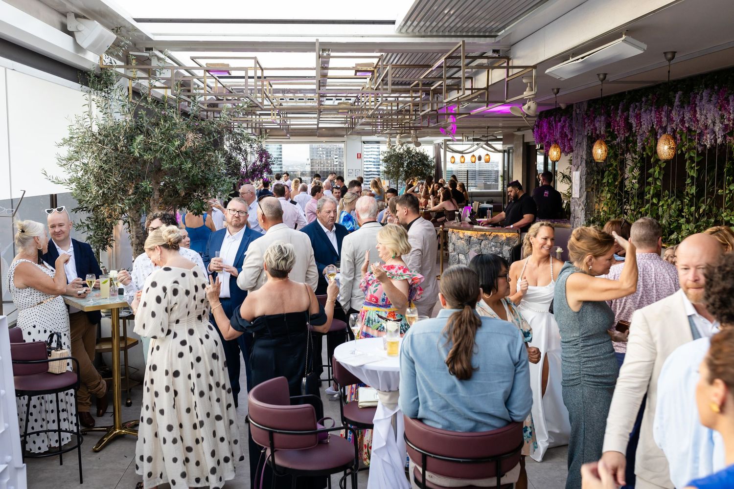 Wedding reception guests mingling in an indoor-outdoor rooftop venue space.Brisbane wedding venue