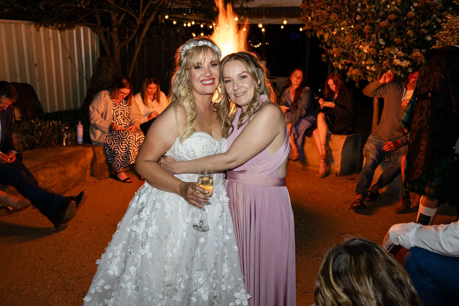 Wedding celebration at night with warm lighting and guests dancing.