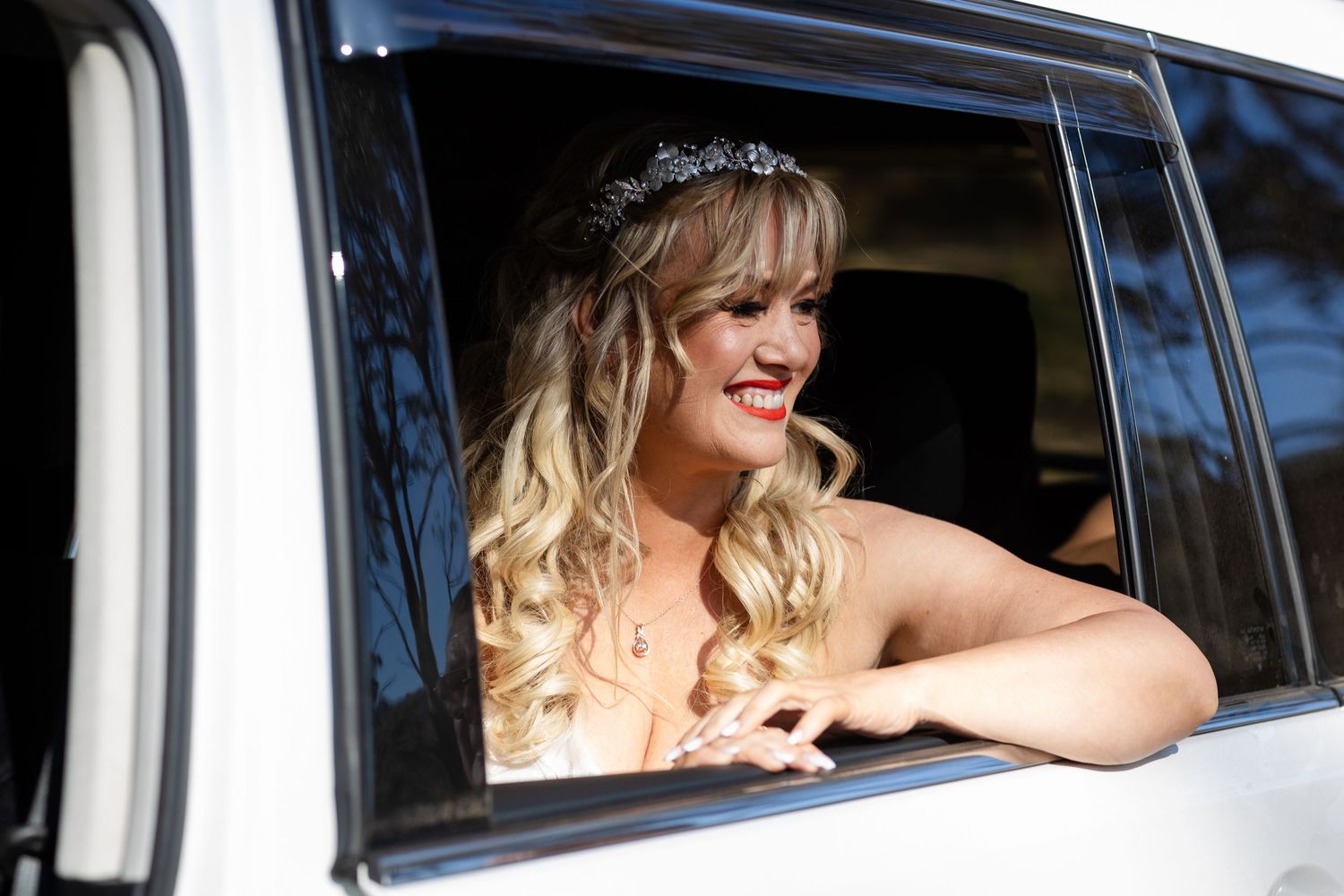 Vintage car window framing a view of passengers during a special occasion.