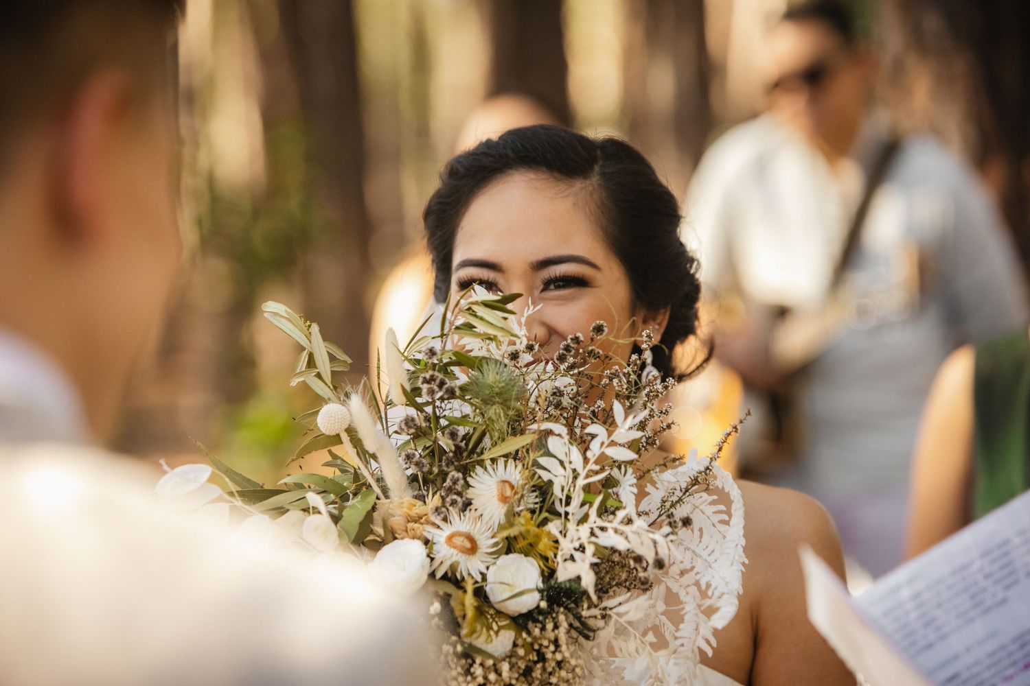 Wedding party poses with delicate floral bouquets in a rustic outdoor setting.pizzey park wedding Gold Coast