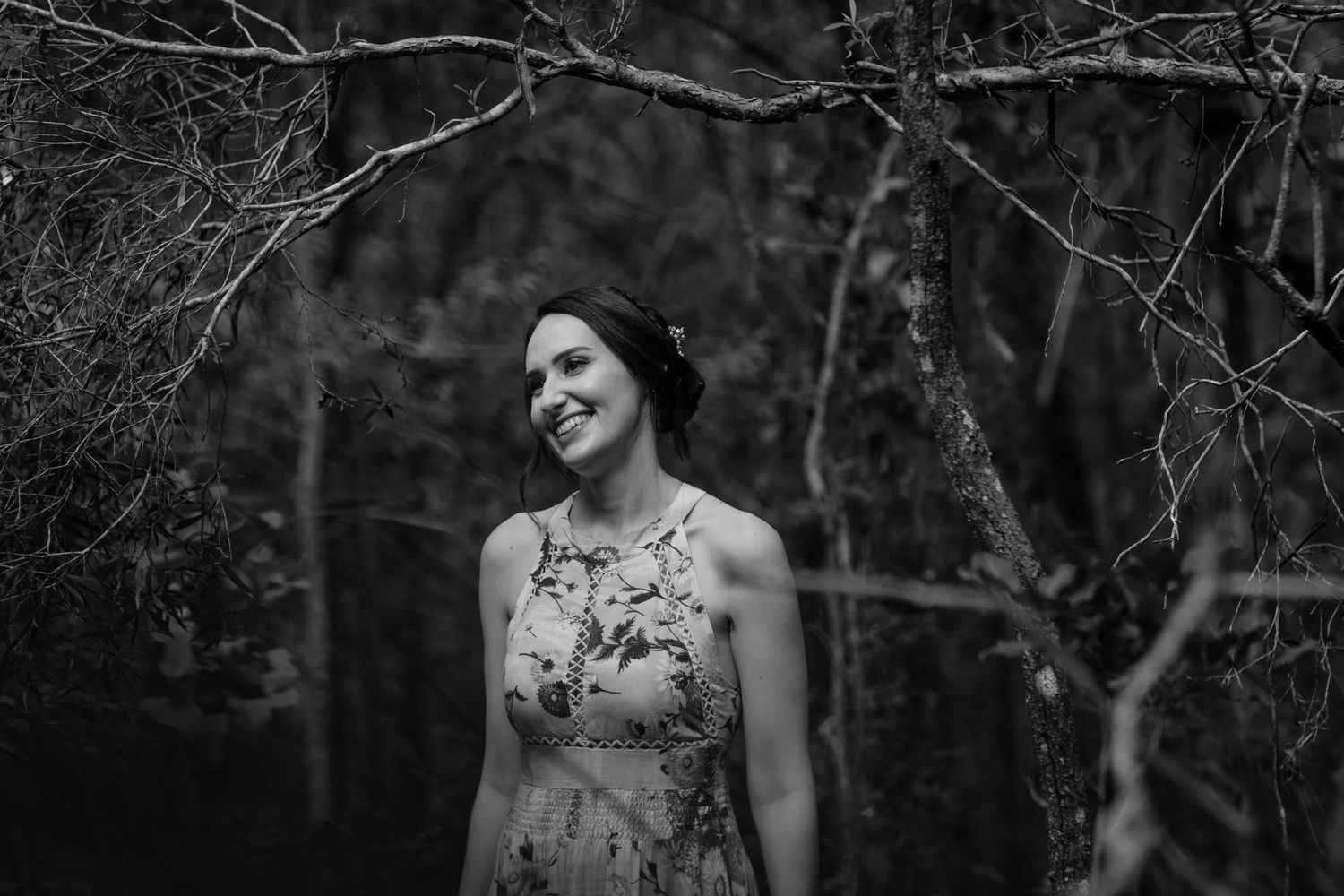 Black and white portrait of two people sharing a joyful moment in a wooded setting.Gold Coast elopement photographer