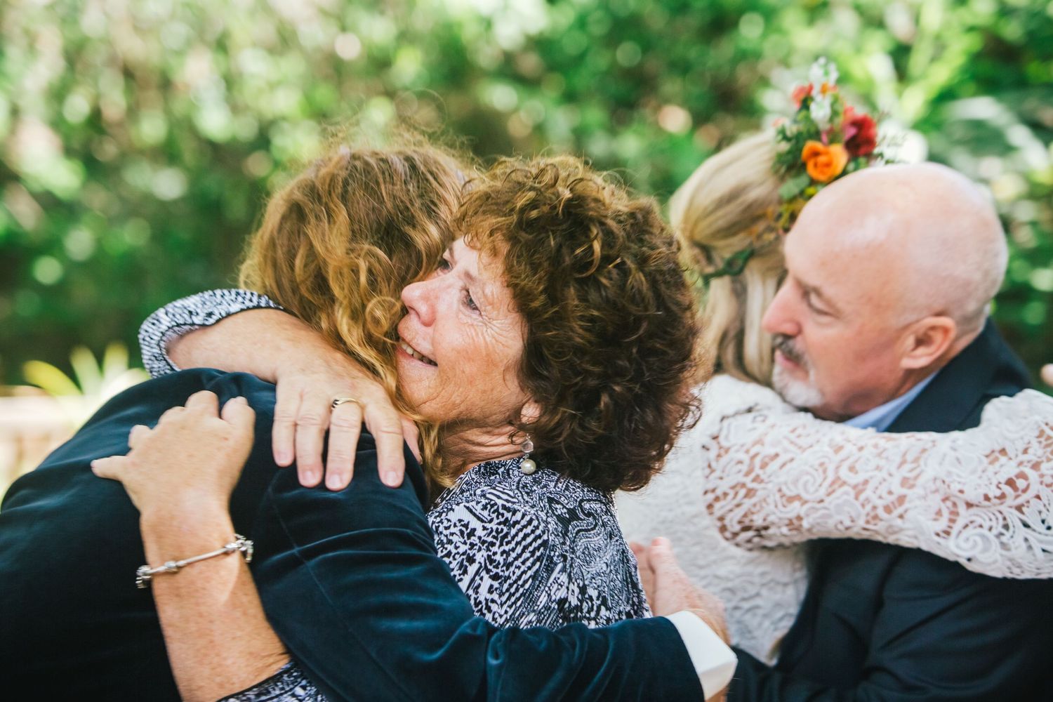 Emotional group hug captured during wedding celebration outdoors.DIY wedding Gold Coast elopement photographer Gold Coast