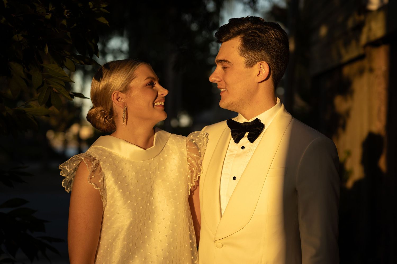 Golden hour wedding portrait with soft natural lighting and formal attire.