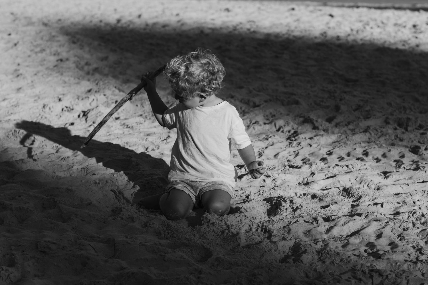 Long shadows cast on beach sand during a sunset walk.Gold Coast candid family photographer.
