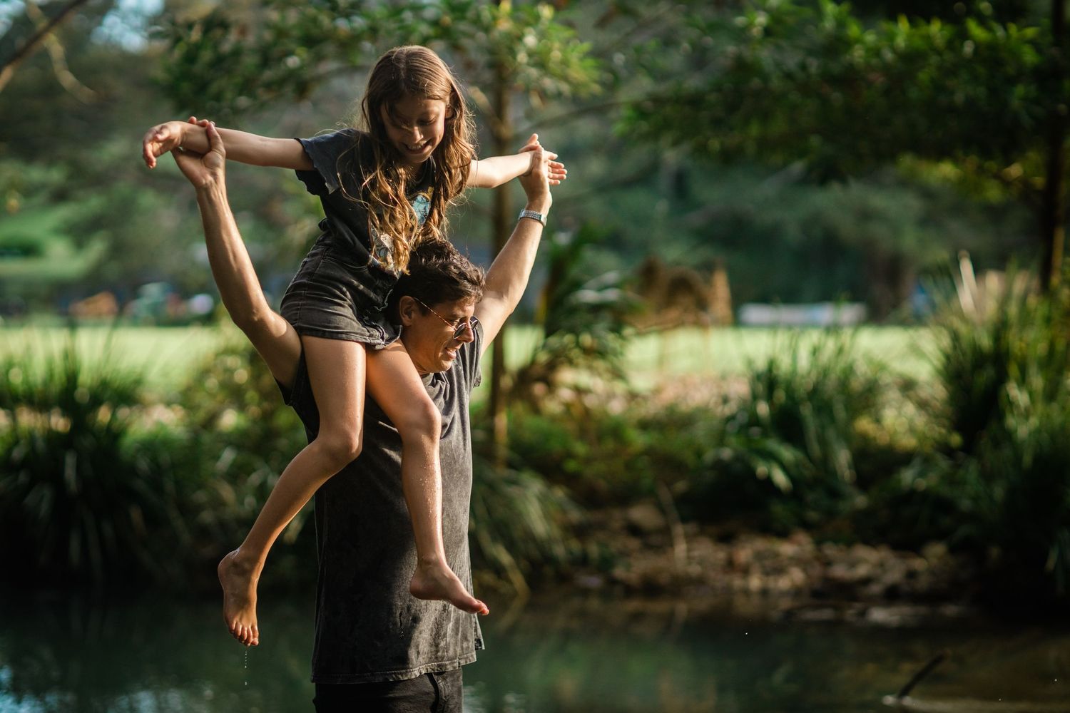 Playful summer moments captured of children enjoying nature by a creek.Gold Coast candid family photographer.