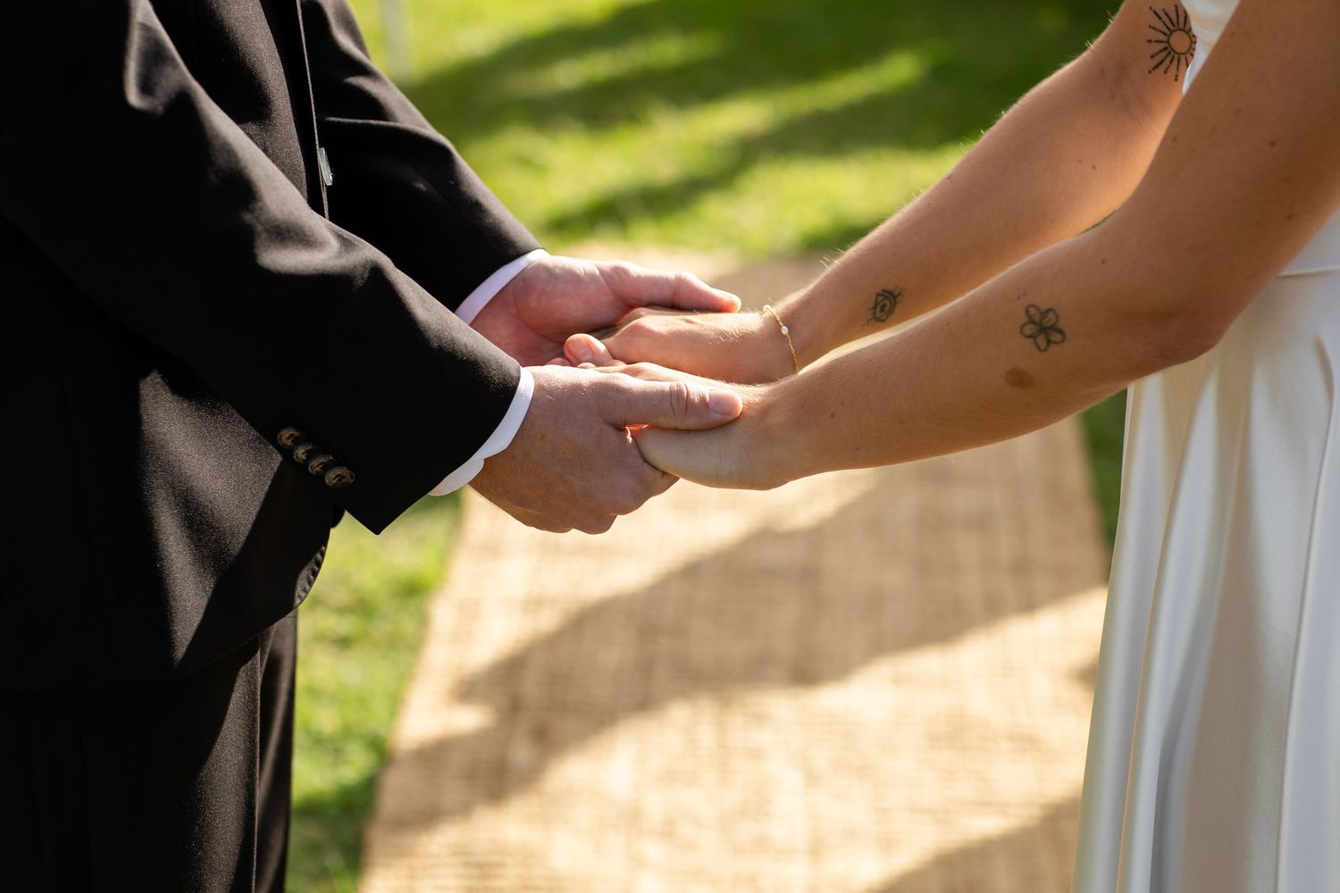 Close-up of hands exchanging rings during an outdoor wedding ceremony.beach wedding currumbin surf club wedding