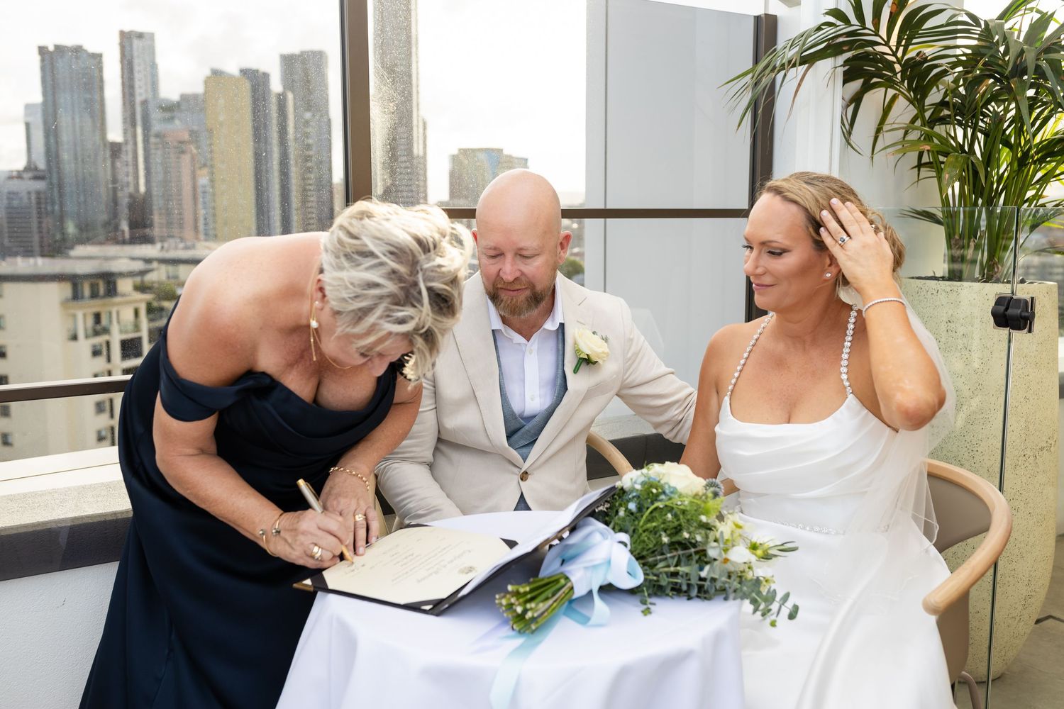 Wedding party gathered on a modern rooftop venue with city skyline views.