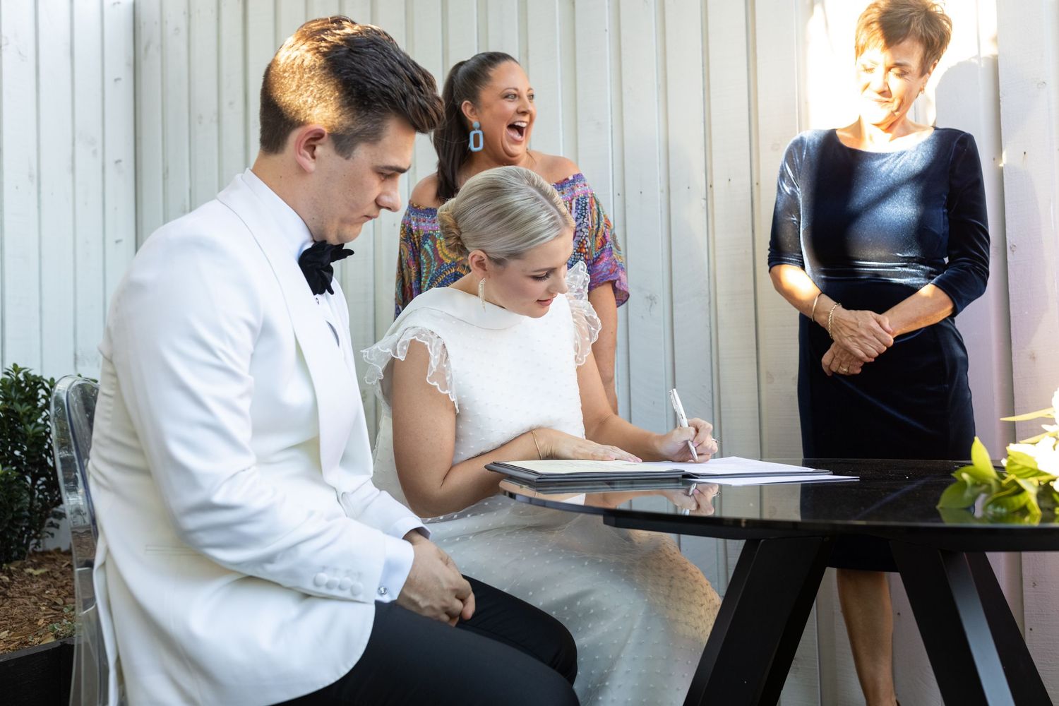 Wedding guests mingle and socialize during an outdoor reception celebration.