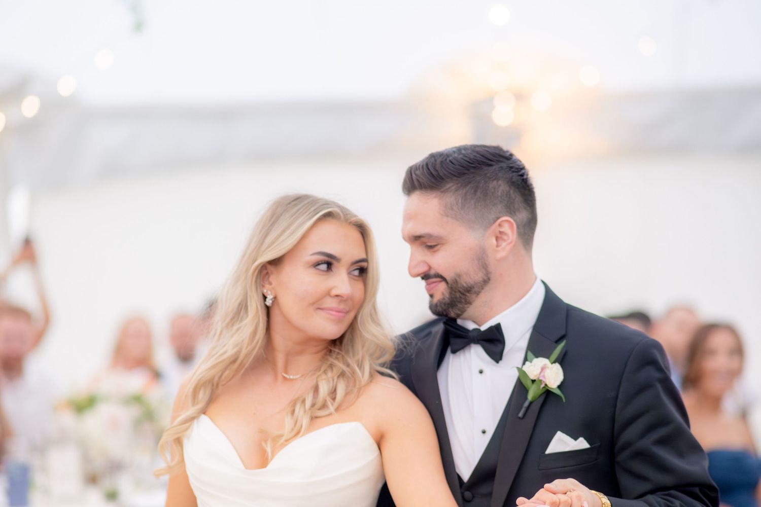 Bride and groom sharing intimate first dance moment with sparklers glowing in the background.