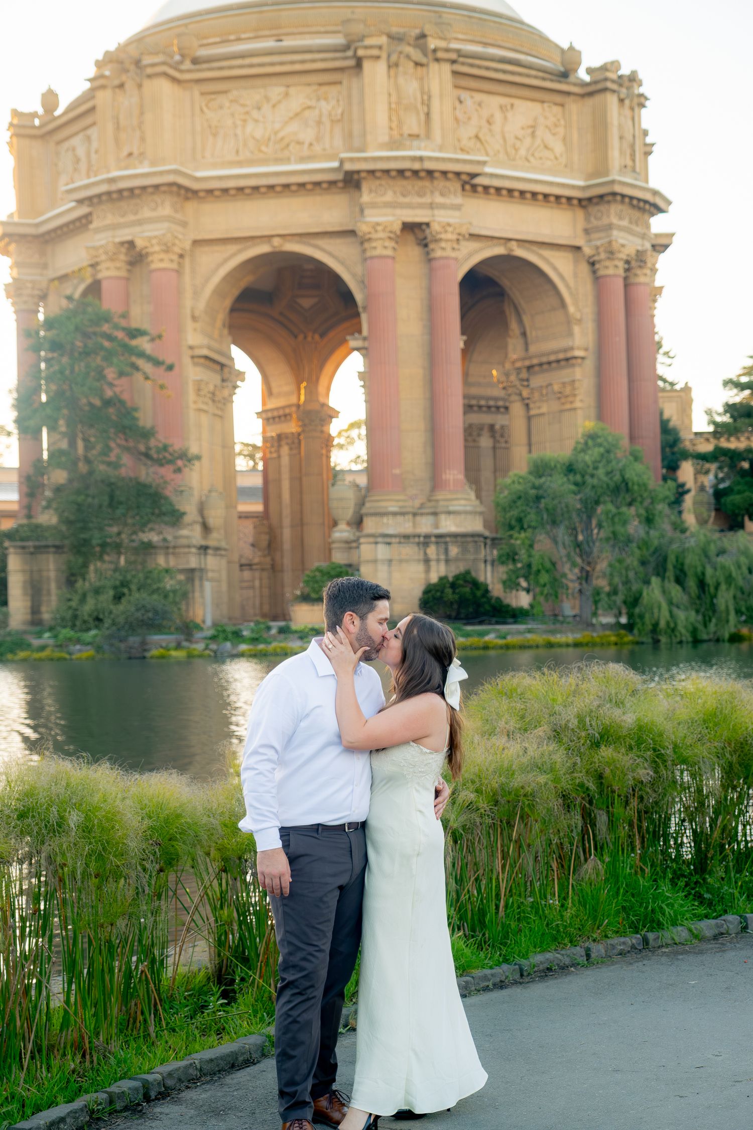 Couple sharing a romantic kiss in front of the Palace of Fine Arts rotunda in San Francisco, CA.