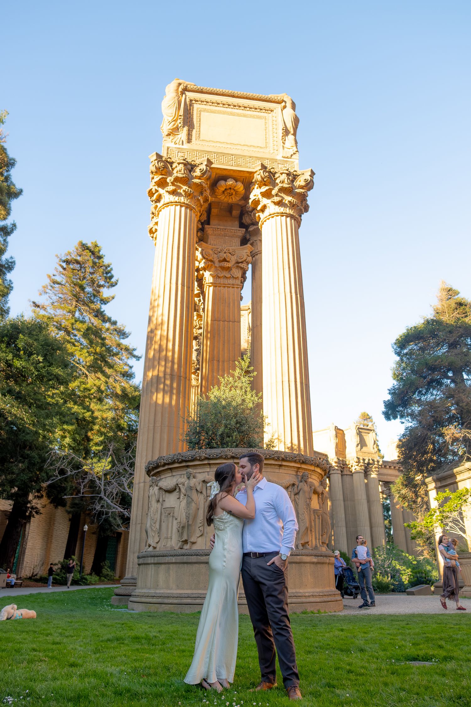 Couple kissing in front of grand Roman columns at the Palace of Fine Arts in San Francisco.