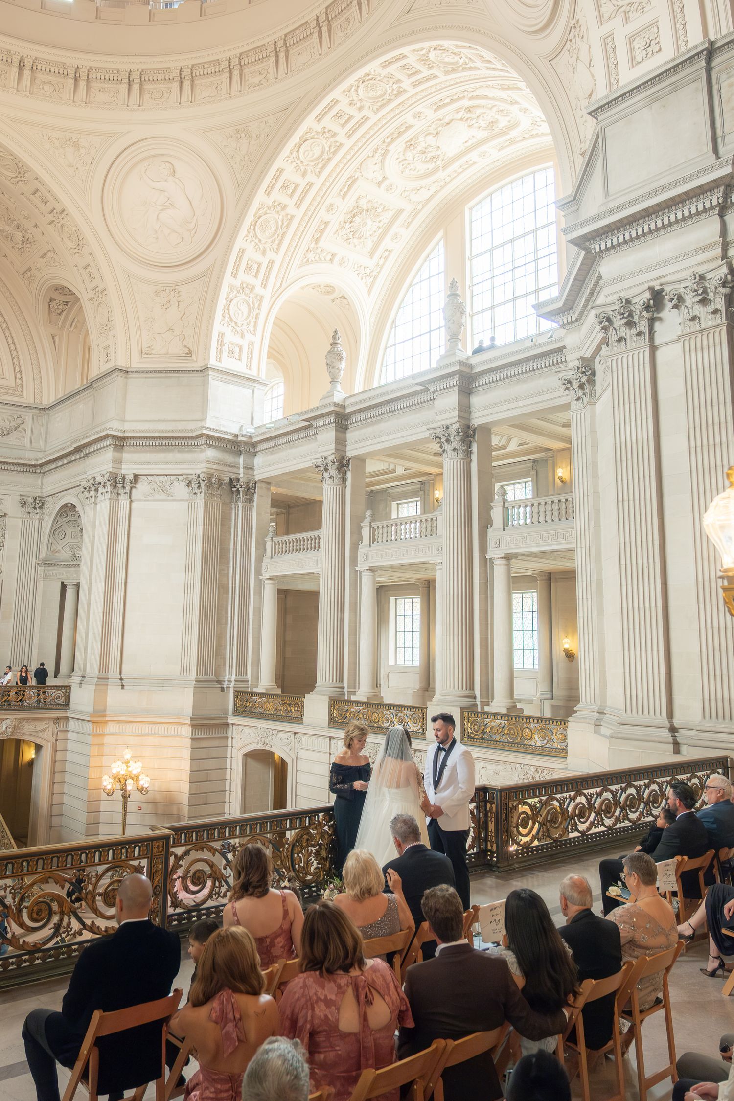 Intimate wedding ceremony at San Francisco City Hall with guests seated beneath the grand rotunda.