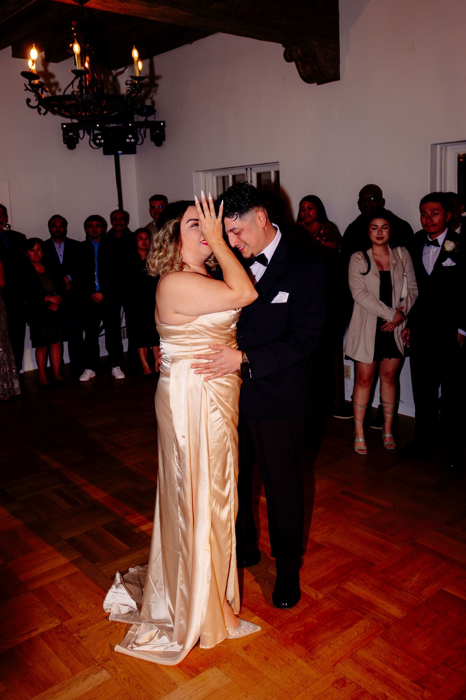 Bride and groom share their first dance in elegant attire at a romantic wedding reception.
