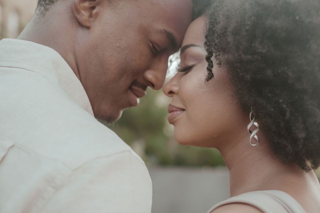 Close-up of a Black couple touching foreheads tenderly in an intimate and romantic moment.