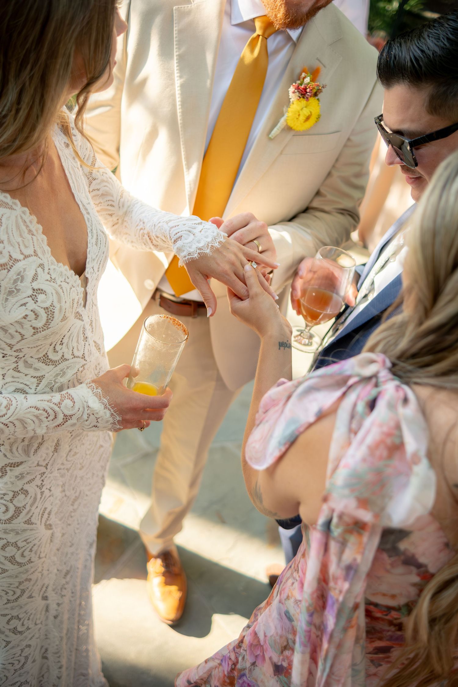 Bride and groom exchanging rings during an outdoor wedding ceremony with guests watching closely.