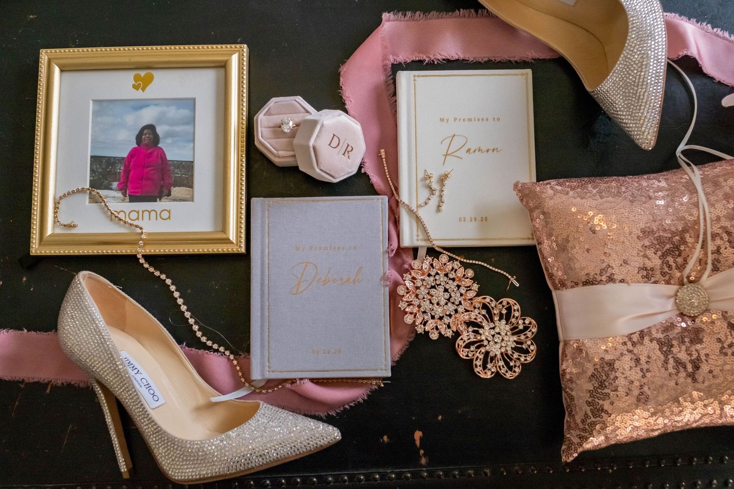 Wedding flat lay with glitter heels, invitation suite, ring pillow, and rose gold accessories.