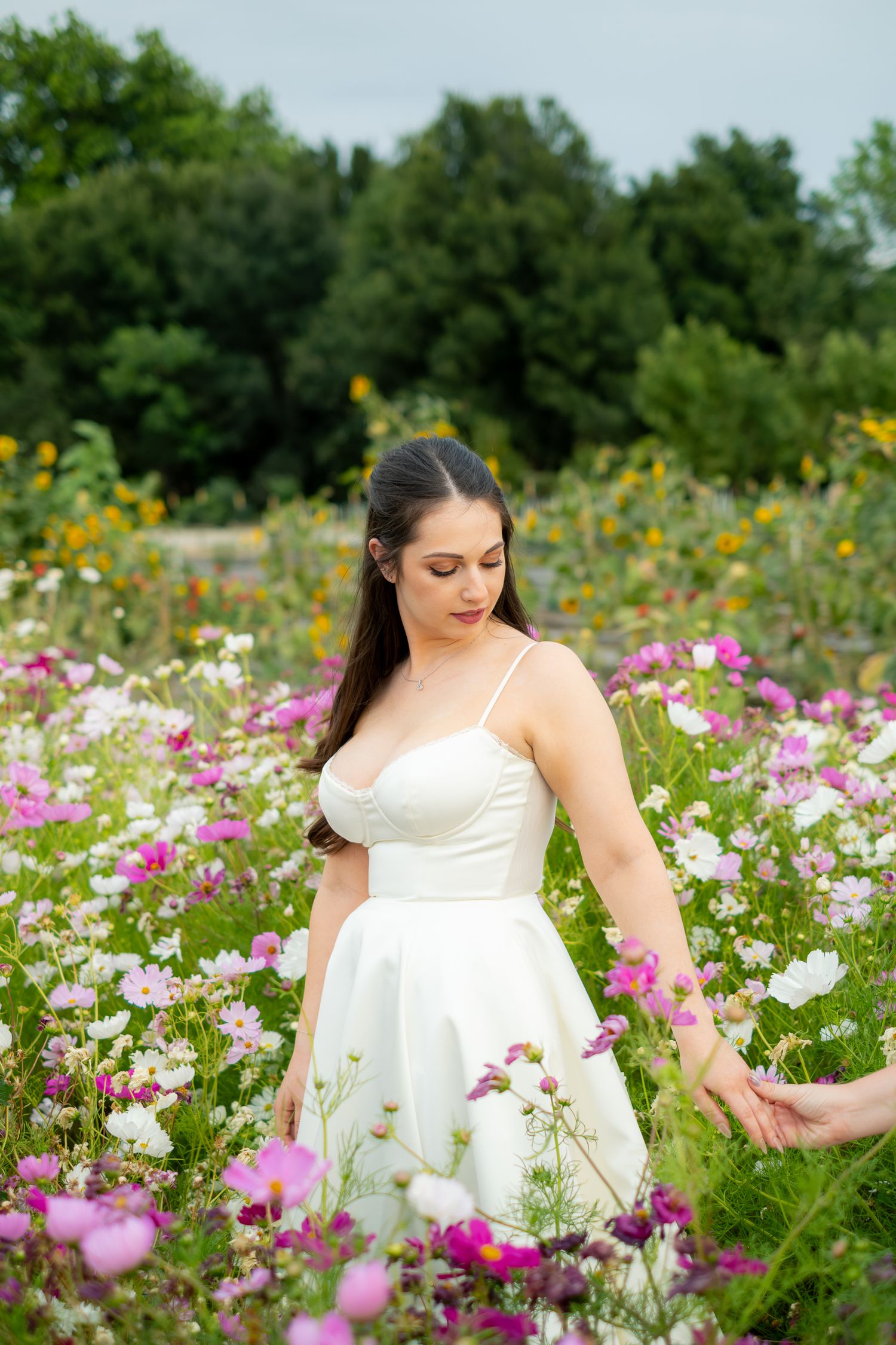 A bride in a white dress walks through a colorful wildflower field on her wedding day.