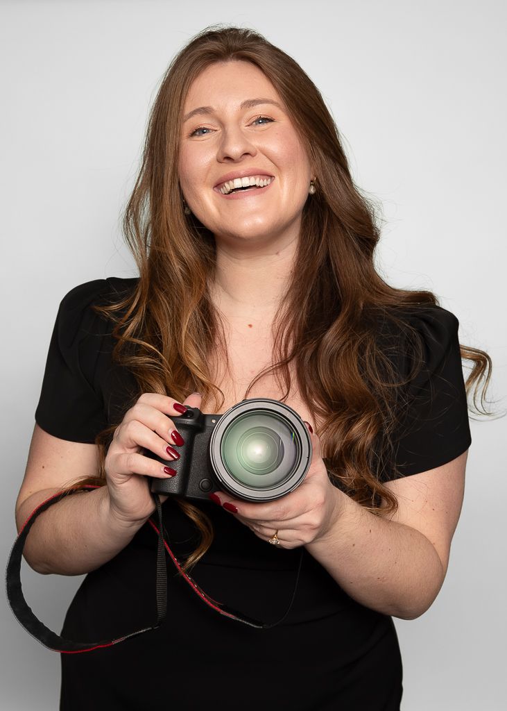 A photographer displays camera gear with animated expressions in studio portraits.